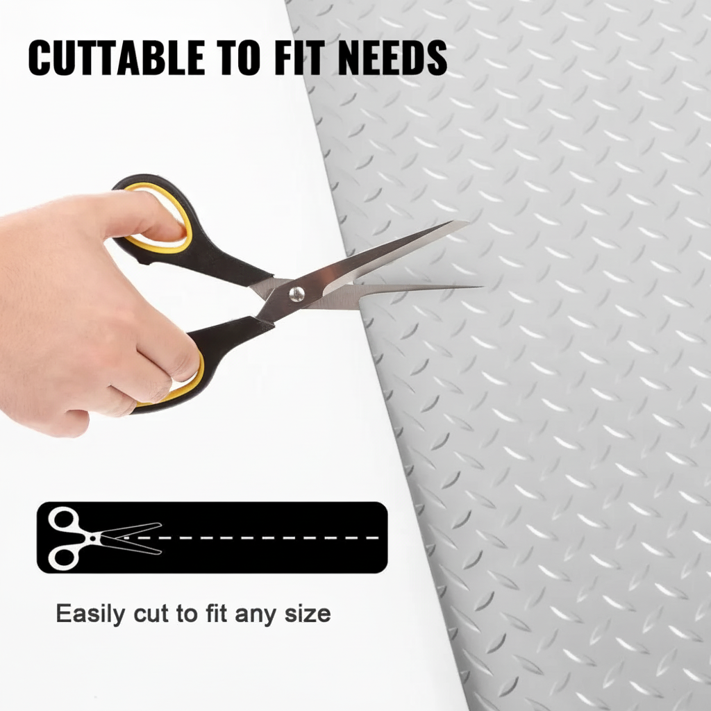 Hand cutting grey PVC diamond tread garage floor mat with scissors showing it can be cut to any size